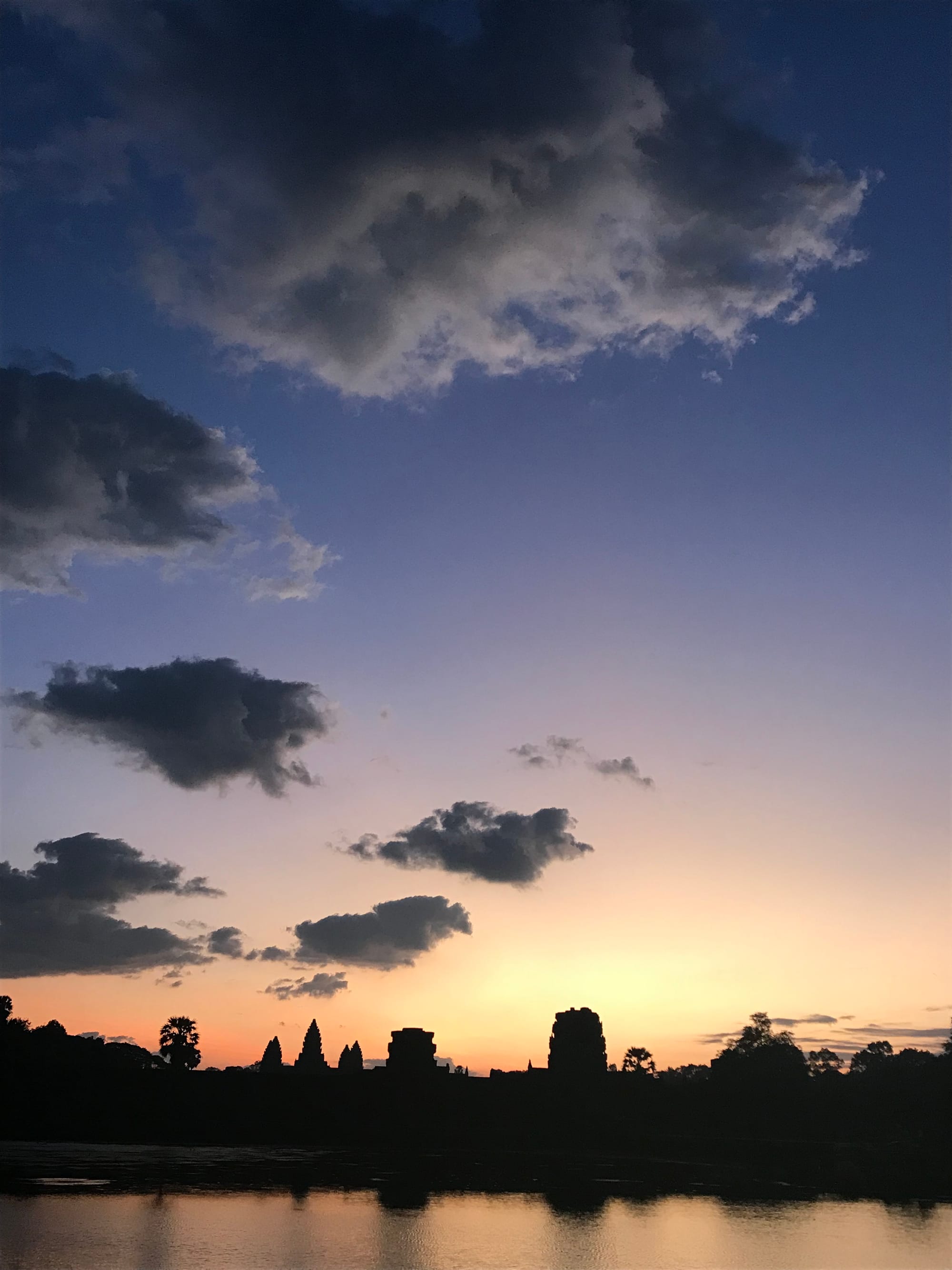 A mellow orange sunrise with the stupas of Angkor in silhouette. 