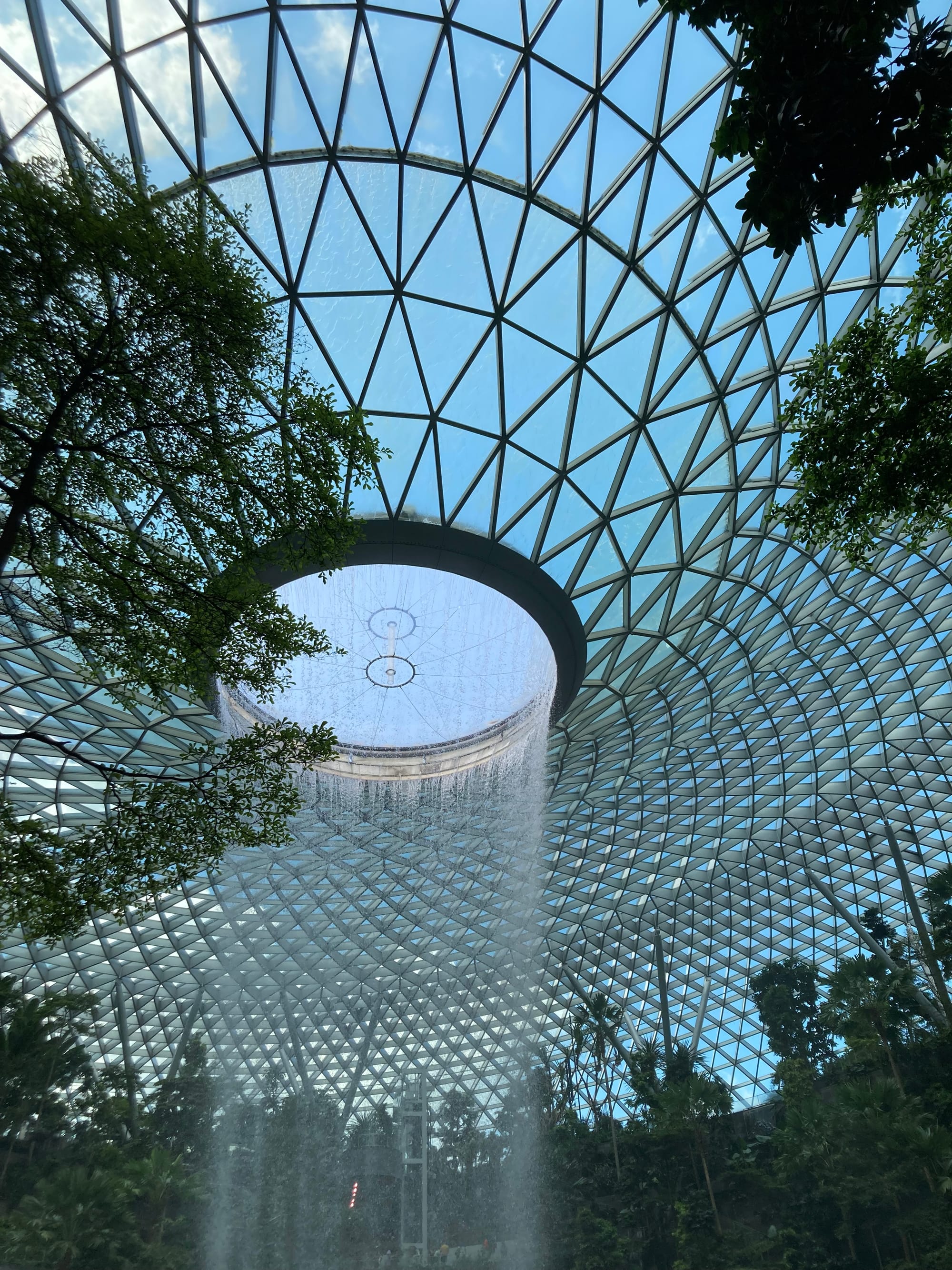 A view of the glass panelled ceiling reinforced with triangular metalwork and the hole through which the water pours down.