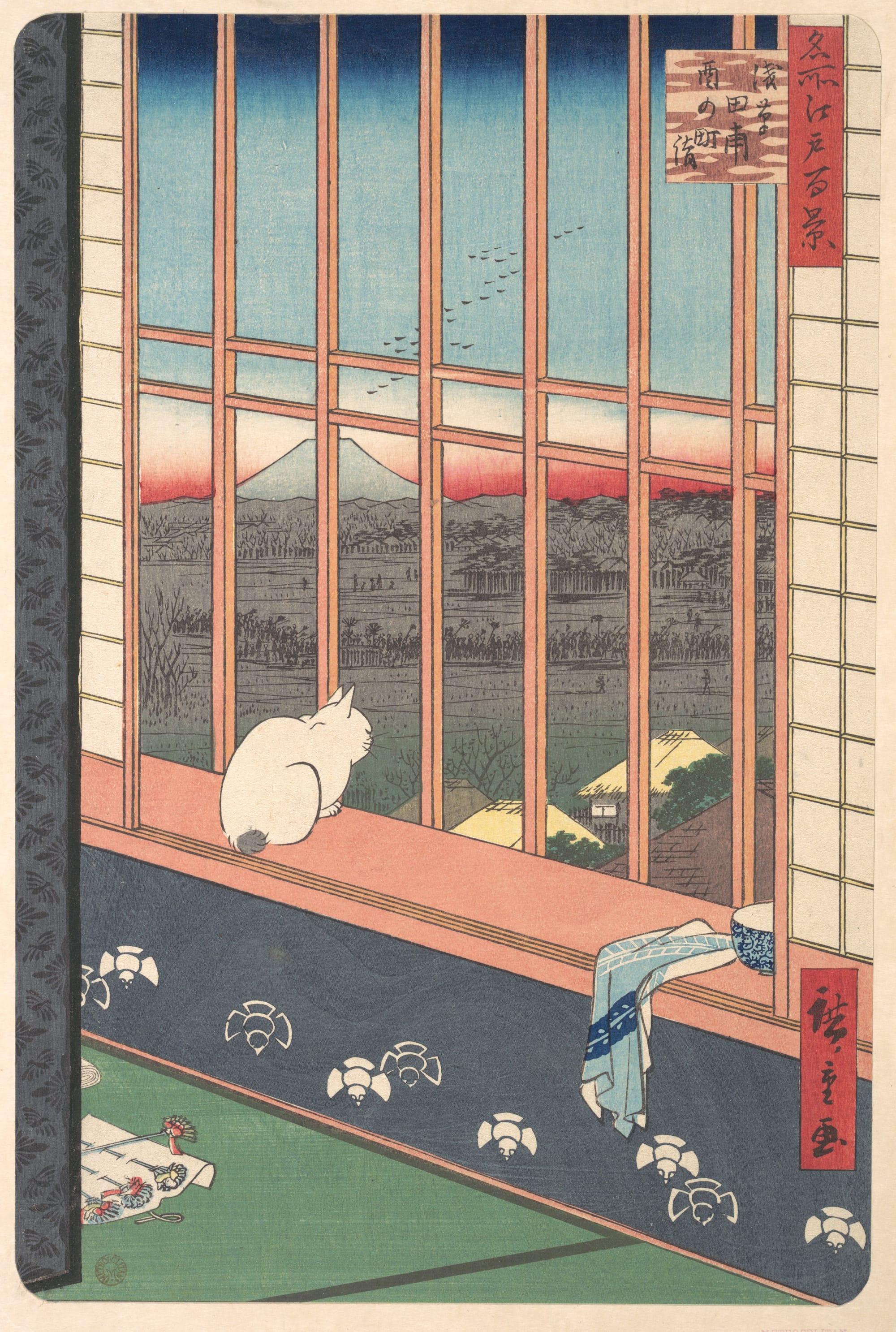 A white cat sits on a ledge looking out onto houses, fields, and a mountain