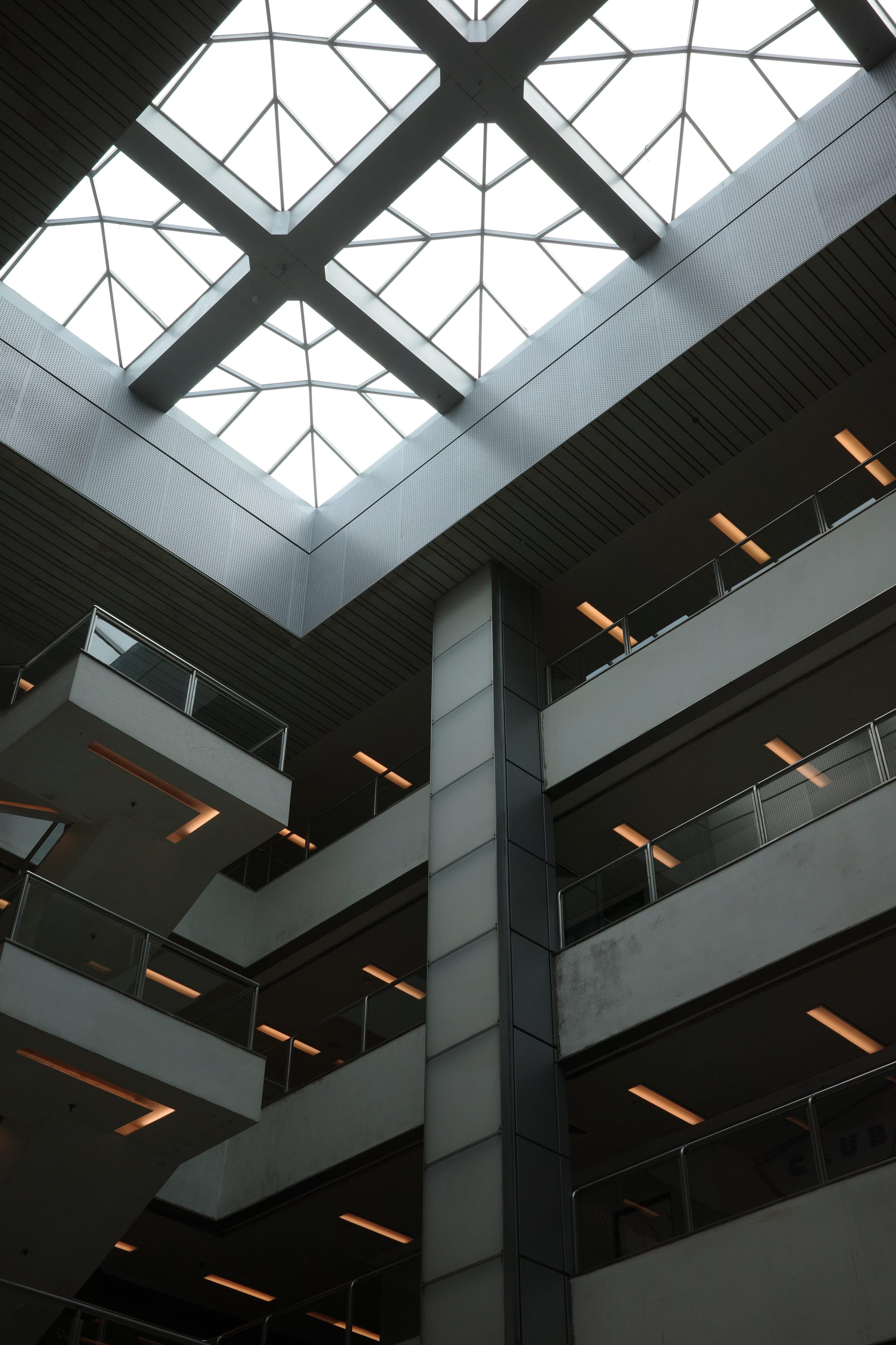 A view of the skylight in an atrium mall. We can also see the fluorescent lighting on each floor of the mall.