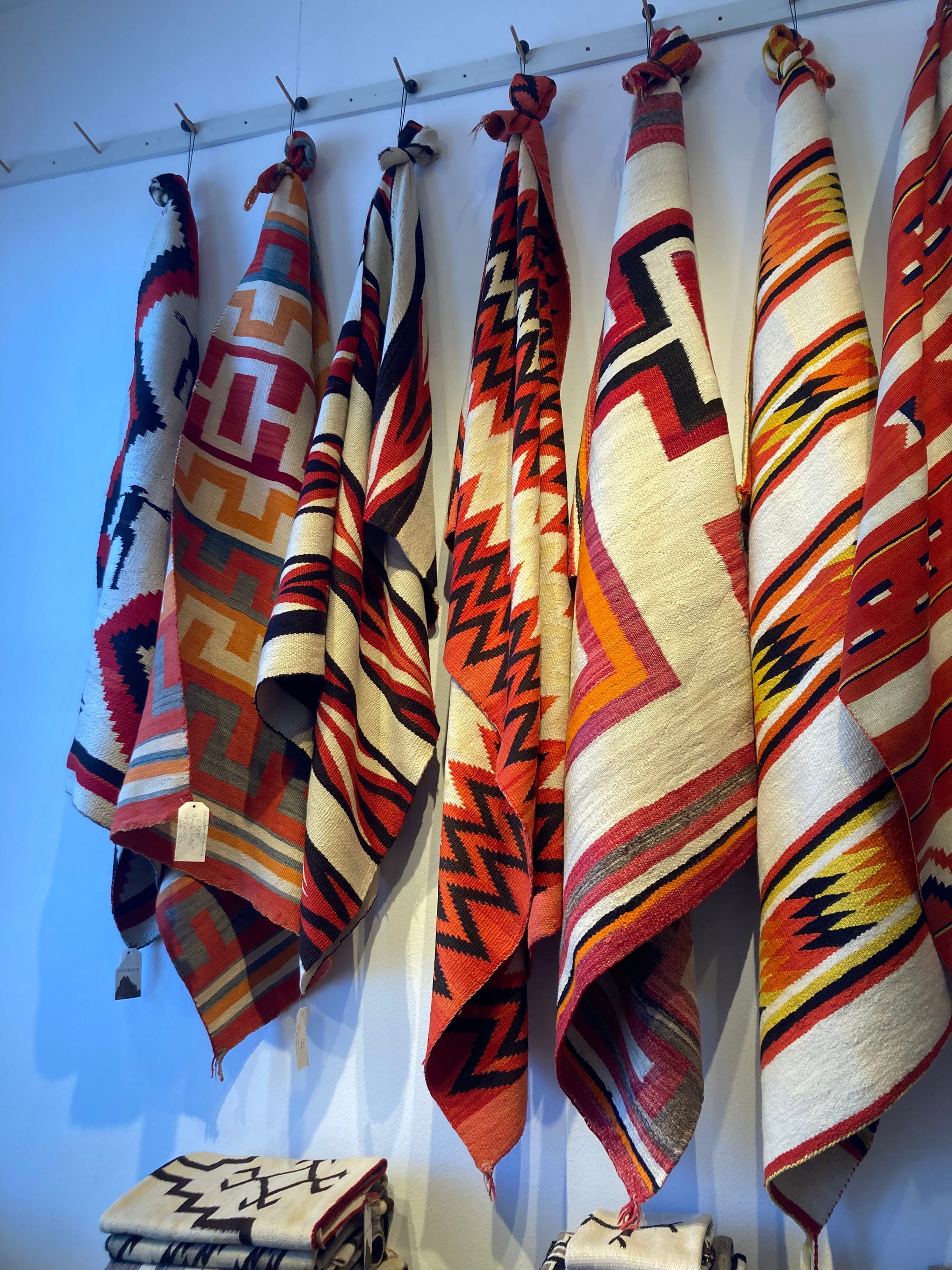 Red, white and black Navajo rugs hung on a wall