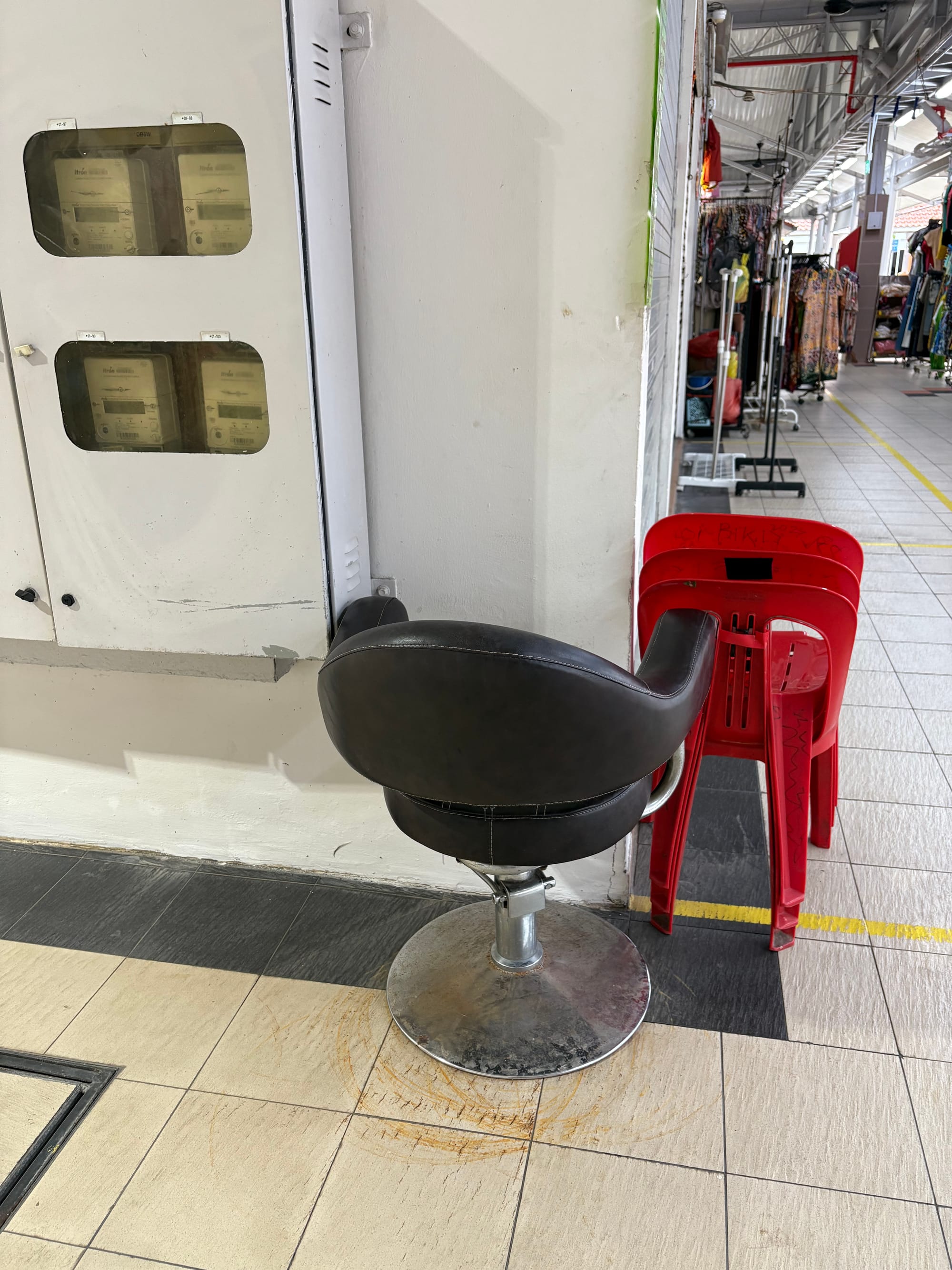 A black leather bar chair is tucked up against a wall. 