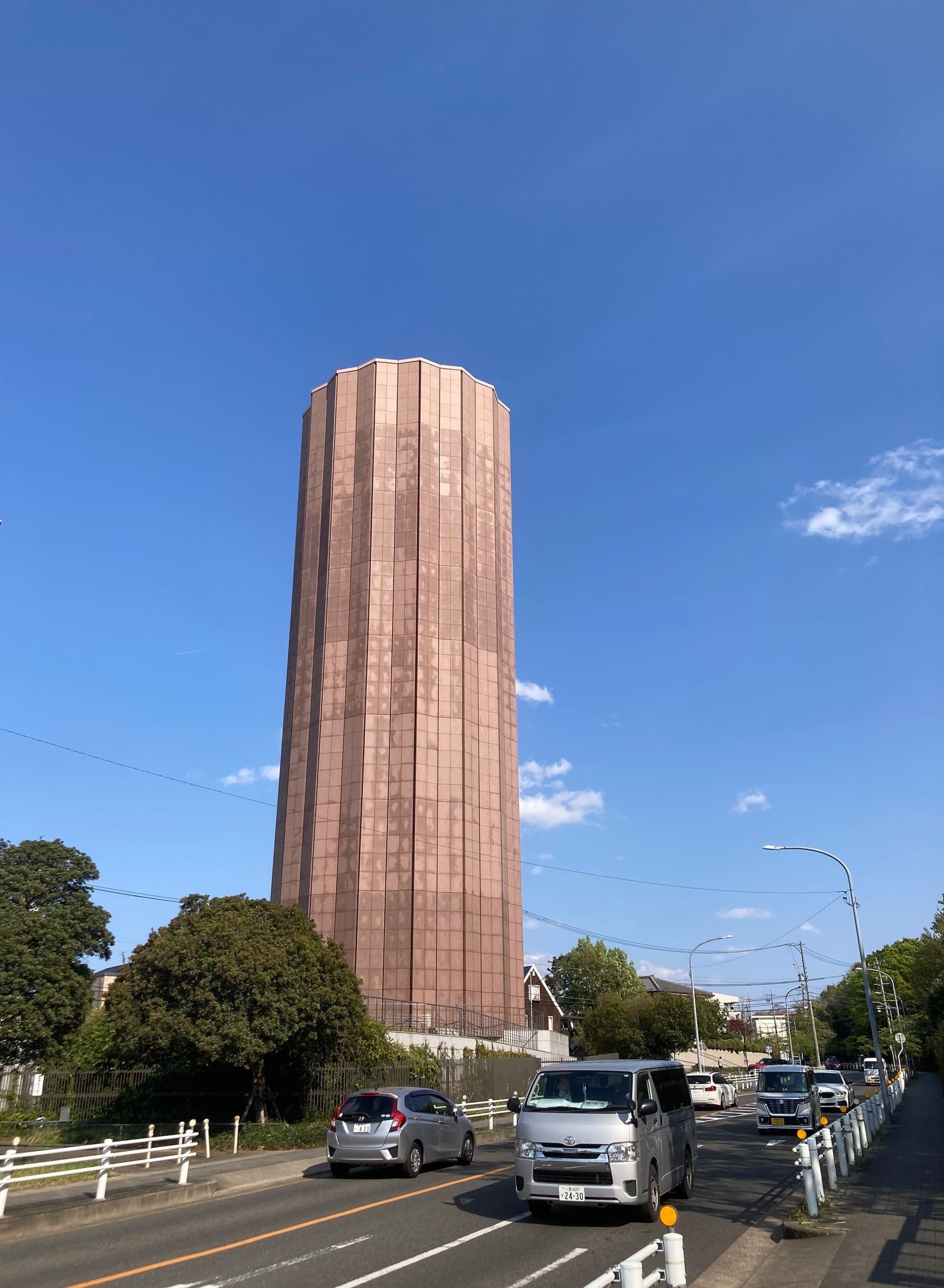 A terracota-coloured tower stands against a blue sky.