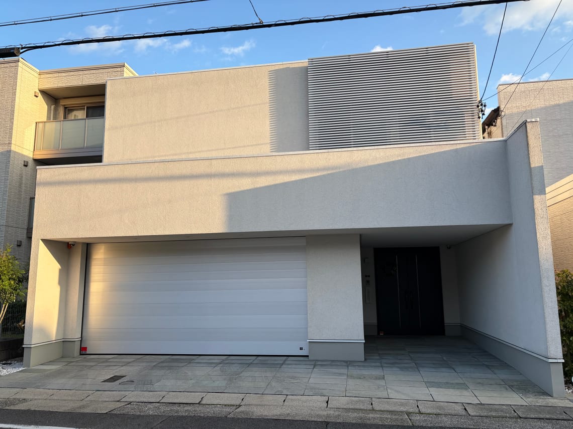 A boxy house in white with no windows